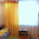Штора на петлях желтого цвета с оранжевой отделкой для детской комнаты